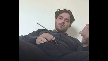 Tatuado em roupa social se divertindo sozinho em seu sofá