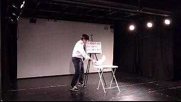 ネクタイの男は紙をめくって披露する