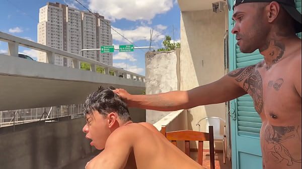 Novinho acabou sendo fudido gostoso na sacada, enquanto pessoas passavam. E acabou tomando cada gota do leite protéico do macho pauzudo.