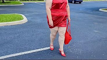 Beautiful woman walking outdoors in public parking lot showing off for strangers