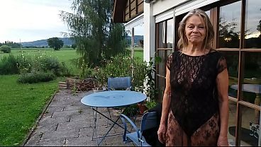 A mature woman shows off her figure outside in a lace bodysuit!